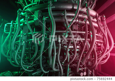 A modern gas turbine aircraft engine in a futuristic red-green light. A modern gas turbine aircraft engine in a futuristic red-green light. 75692444