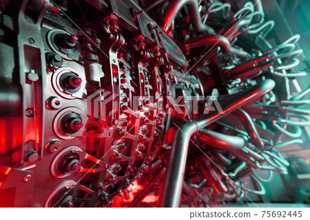 A modern gas turbine aircraft engine in a futuristic red-green light. A modern gas turbine aircraft engine in a futuristic red-green light. 75692445