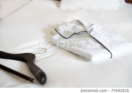 Pajamas and hangers on the hotel bed Pajamas and hangers on the hotel bed 75692828
