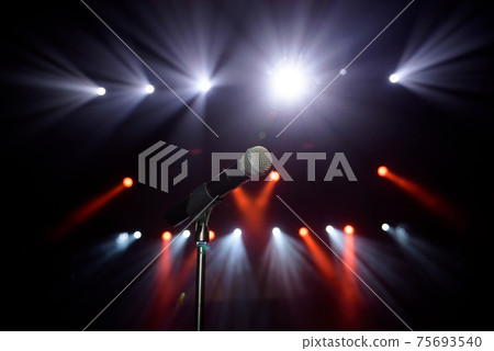 Close-up of microphone at concert against blur colorful light background Close-up of microphone at concert against blur colorful light background 75693540