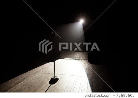 Microphone in a smoke on a dark background in the beam of light. 75693603