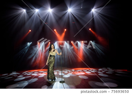Young woman with microphone in hand on entertainment event. 75693650