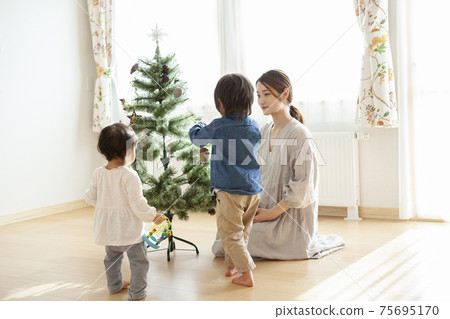 Families decorating Christmas trees Families decorating Christmas trees 75695170