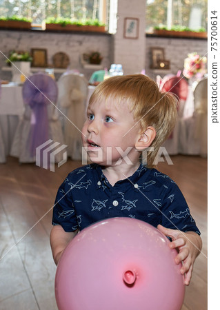 A child holding a large pink balloon A child holding a large pink balloon 75700614