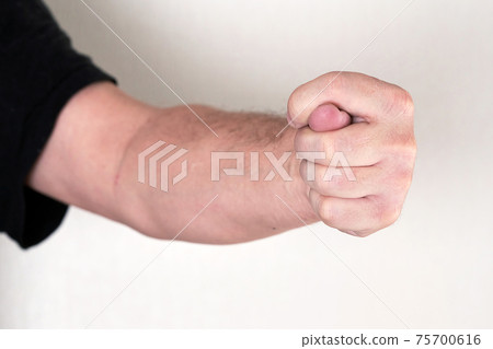 A man hand clenched into a fist shows a fig A man hand clenched into a fist shows a fig 75700616
