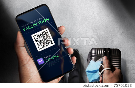 Health Vaccine Passport for Coronavirus or Covid-19. Traveller Using Mobile Phone with Vaccination in Immune Status to Certificated International Traveling  in Airport 75701038