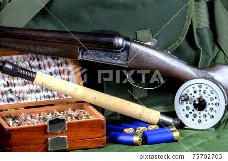 Shotgun with Fishing Rod and Fly Box and Fly Reel and Cartridges with Game Bag on Outdoor Coat 75702703