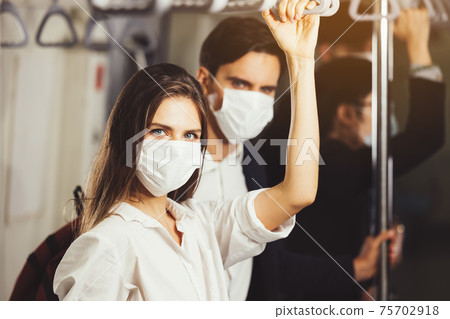 People on the train wear anti-virus masks and travel during rush hours. passengers inside the Sky Train with the masks on all people's faces. 75702918