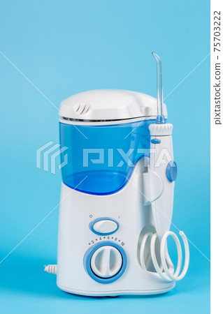 Electronic Tooth Irrigator for personal home usage on blue background. Electronic Tooth Irrigator for personal home usage on blue background. 75703222