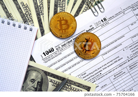 The pen, bitcoins and dollar bills is lies on the tax form 1040 U.S. Individual Income Tax Return. The time to pay taxes The pen, bitcoins and dollar bills is lies on the tax form 1040 U.S. Individual Income Tax Return. The time to pay taxes 75704166