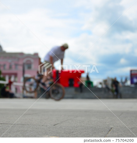 Defocused image of a lot of people with bmx bikes. Meeting of fans of extreme sports Defocused image of a lot of people with bmx bikes. Meeting of fans of extreme sports 75704200