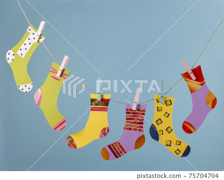 World Down Syndrome Day concept. Different socks in clothesline on blue background. World Down Syndrome Day concept. Different socks in clothesline on blue background. 75704704