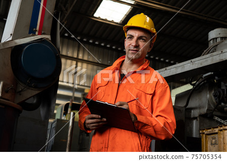Skillful factory worker working with clipboard to do job procedure checklist . Skillful factory worker working with clipboard to do job procedure checklist . 75705354
