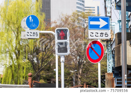 Pedestrian traffic lights and traffic signs at urban intersections Pedestrian traffic lights and traffic signs at urban intersections 75709556