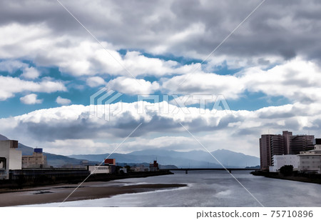 Bright white clouds are about to roll over the city of Kagoshima, in Japan. 75710896
