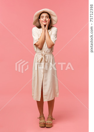 Full-length vertical portrait happy cheerful woman feeling uplifted and dreamy, close eyes smiling touching face, moisturizer walking on sunny perfect day, standing pink background Full-length vertical portrait happy cheerful woman feeling uplifted and dreamy, close eyes smiling touching face, moisturizer walking on sunny perfect day, standing pink background 75712398