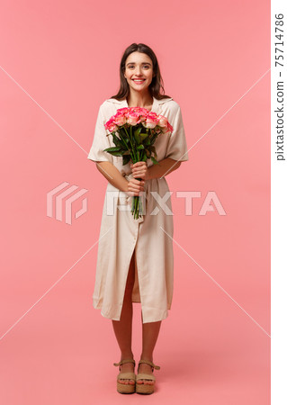 Full-length vertical portrait attractive, lovely young woman receiving beautiful flowers, holding bouquet enjoying romantic date, smiling happily, standing pink background delighted Full-length vertical portrait attractive, lovely young woman receiving beautiful flowers, holding bouquet enjoying romantic date, smiling happily, standing pink background delighted 75714786