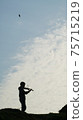 Silhouette of girl playing violin on hillside 75715219