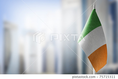 A small flag of Ireland on the background of a blurred background 75715311