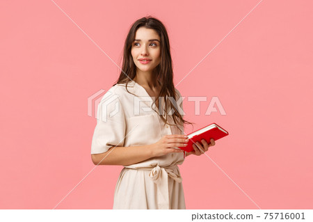 Attractive dreamy and romantic cute girl in dress turn around looking camera thoughtful, holding notebook, prepare notes for work, standing pink background, thinking Attractive dreamy and romantic cute girl in dress turn around looking camera thoughtful, holding notebook, prepare notes for work, standing pink background, thinking 75716001