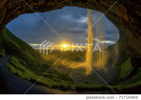 Seljalandsfoss waterfall against the backdrop of a bright sunset. Iceland Seljalandsfoss waterfall against the backdrop of a bright sunset. Iceland 75716469