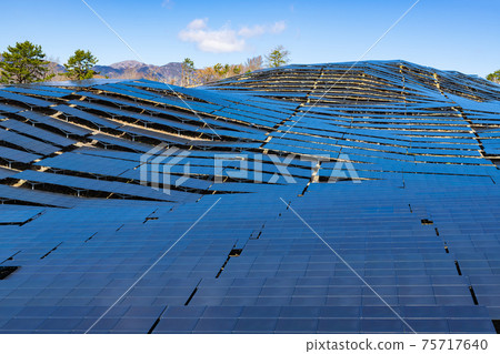 A large number of solar panels (power generation equipment) installed on the slopes of mountains 75717640