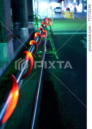 A safety tube that looks like a red glowing illumination in the night view of the city A safety tube that looks like a red glowing illumination in the night view of the city 75719246