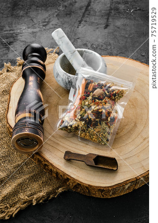 Wooden cross section with set for mulled wine spices in plastic package and mortar and mill 75719529