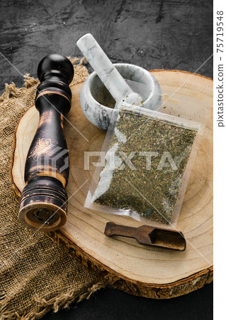 Wooden cross section with Provencal herbs in plastic package and mortar and mill 75719548