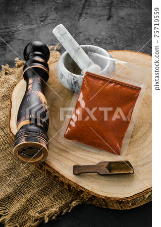 Wooden cross section with chilli pepper in plastic package and mortar and mill 75719559