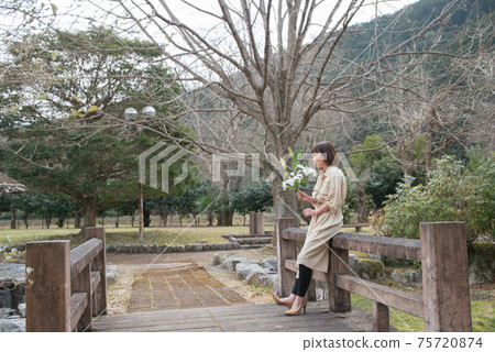 Young woman with lily flowers Young woman with lily flowers 75720874