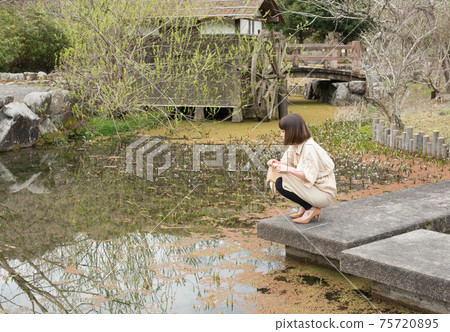 Young woman with lily flowers Young woman with lily flowers 75720895