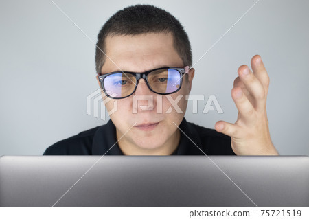 The man looks at the laptop, gets angry and annoyed about what he saw there. Expressing emotions and reacting to what you see on the Internet. Shocking content concept. The man looks at the laptop, gets angry and annoyed about what he saw there. Expressing emotions and reacting to what you see on the Internet. Shocking content concept. 75721519