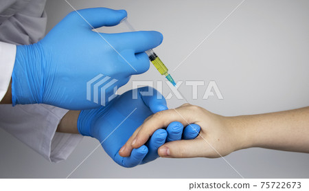 An orthopedic surgeon gives an injection in the finger joint. Treatment of osteoarthritis with hormonal drugs or drugs based on hyaluronic acid. Help with diseases that damage the cartilage of the 75722673