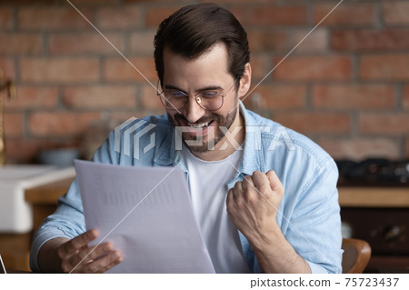 Happy man triumph reading good news in letter 75723437