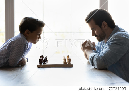Young Caucasian dad and small son ready for chess match 75723605