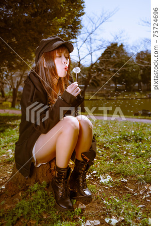 A cute girl fluffs dandelion fluff A cute girl fluffs dandelion fluff 75724696