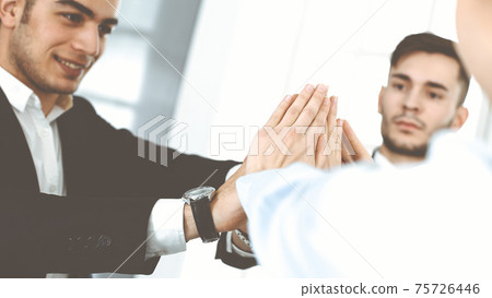 Business people group showing teamwork, joining hands and giving five to each other in modern office. Success concept 75726446