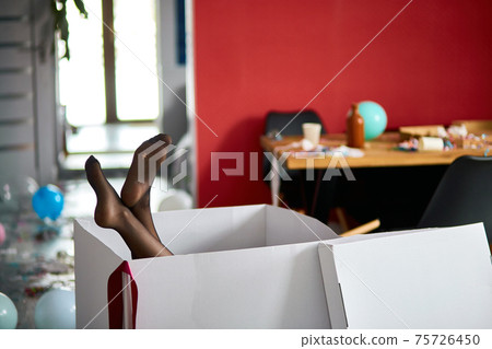 Woman legs sticking from big box with leaky stockings, after party chaos Woman legs sticking from big box with leaky stockings, after party chaos 75726450