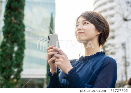 一個在城市使用智能手機的女人 一個在城市使用智能手機的女人 75727705
