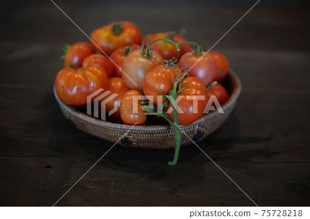 fresh tomatoes in basket on wooden table 75728218