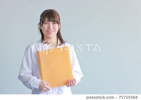 A smiling lab coat woman with an orange file A smiling lab coat woman with an orange file 75729368