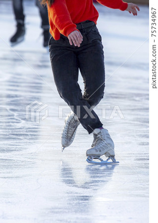 feet on the skates of a person rolling on the ice rink. Hobbies and sports.  75734967
