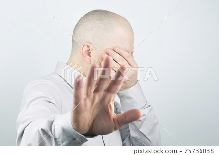 Man covers his face with his hand Man covers his face with his hand 75736038