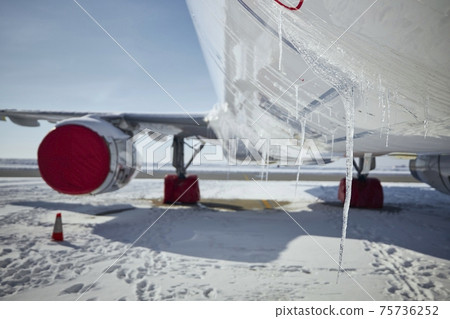 Grounded plane at snowy airport in frosty day Grounded plane at snowy airport in frosty day 75736252
