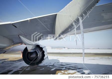 Grounded plane at snowy airport in frosty day 75736255