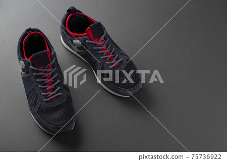Pair of insulated trendy sneakers on a gray background. Pair of insulated trendy sneakers on a gray background. 75736922