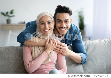 Portrait of loving muslim couple embracing at home Portrait of loving muslim couple embracing at home 75737324