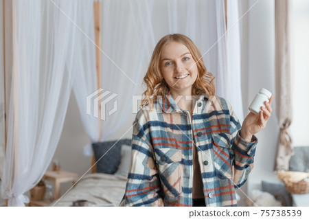 Beautiful blond girl Holding white Bottle With Pills In Hand. Diet. Nutrition. Healthy Eating, Lifestyle. Headache concept, Mockup packaging Beautiful blond girl Holding white Bottle With Pills In Hand. Diet. Nutrition. Healthy Eating, Lifestyle. Headache concept, Mockup packaging 75738539