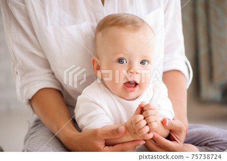 Mom and baby boy in diaper playing in sunny bedroom. Family havi 75738724